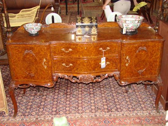 Appraisal: English carved walnut and burl serpentine sideboard waved and molded