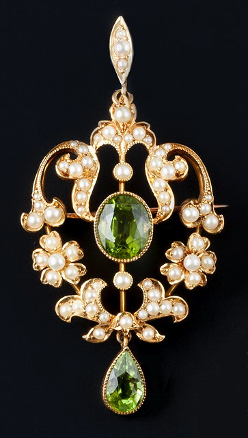 Appraisal: A peridot and seed pearl pendant brooch the openwork cartouche