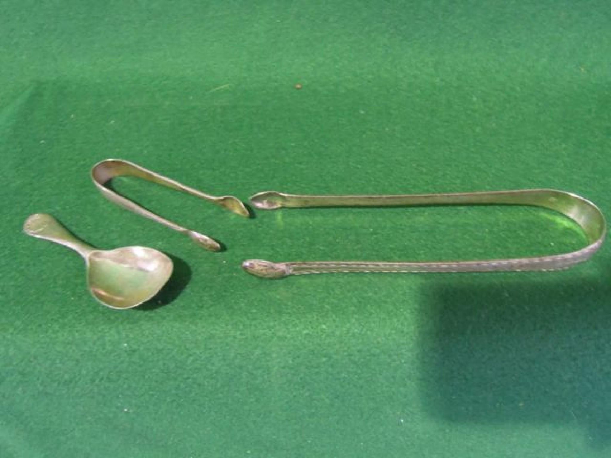 Appraisal: A pair of Georgian sugar tongs a caddy spoon with