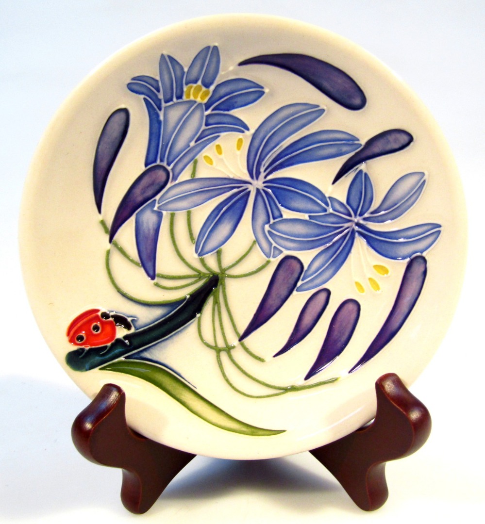 Appraisal: A Moorcroft pottery Fly Away Home Ladybird pattern saucer of