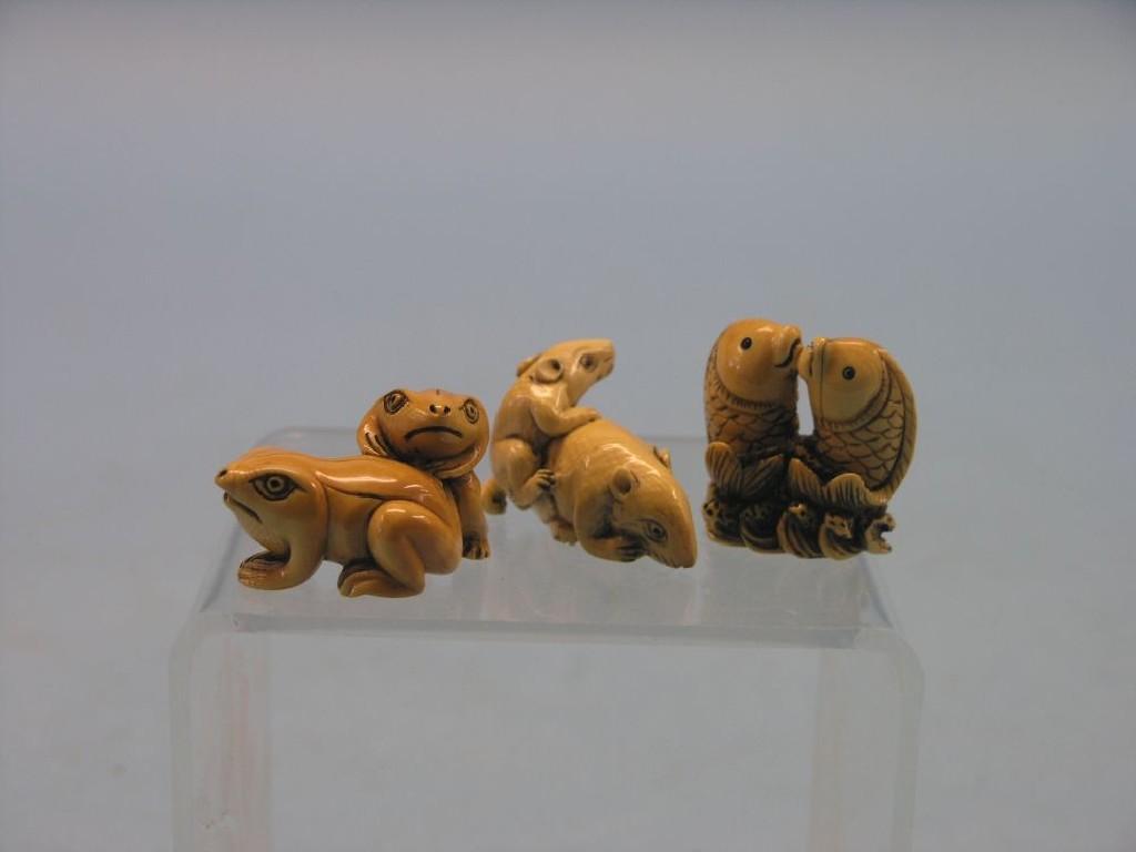 Appraisal: Three Japanese carved ivory netsuke fish group frog group and