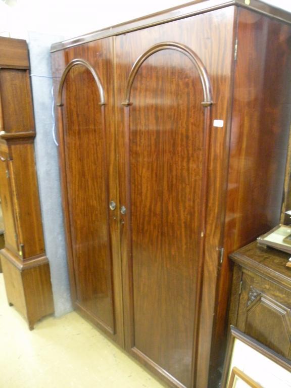 Appraisal: A mahogany wardrobe with two doors each with arched panels