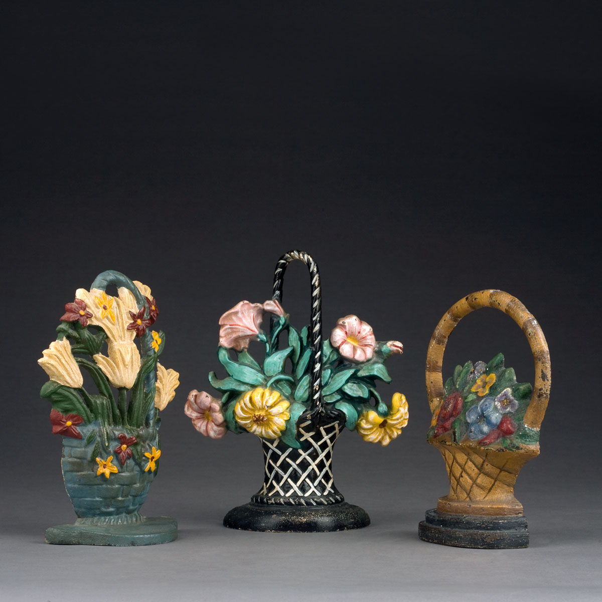 Appraisal: THREE CAST-IRON FLORAL FORM DOORSTOPS