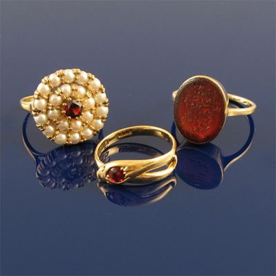 Appraisal: A gold ring mounted with an oval red stone carved