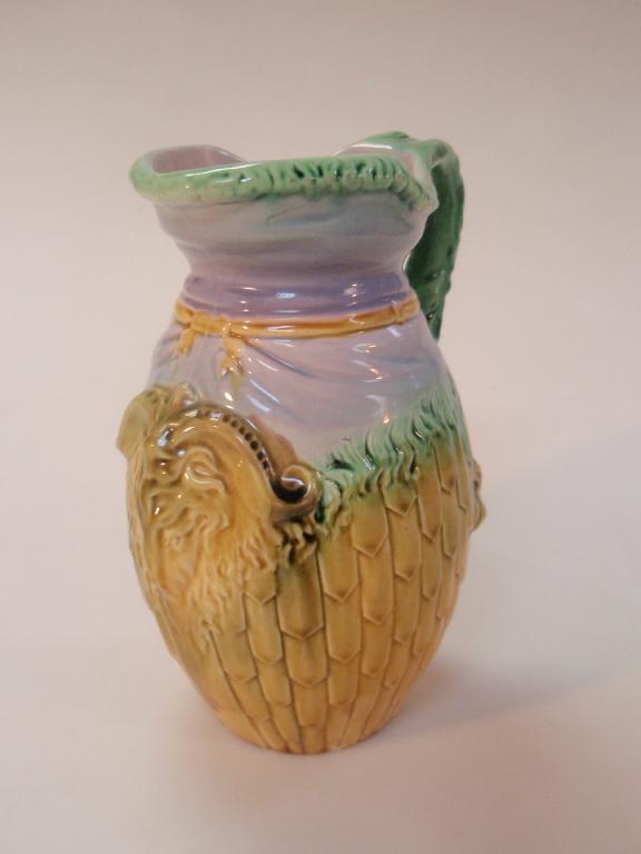 Appraisal: A thC pottery jug moulded with rams head mask overlapping