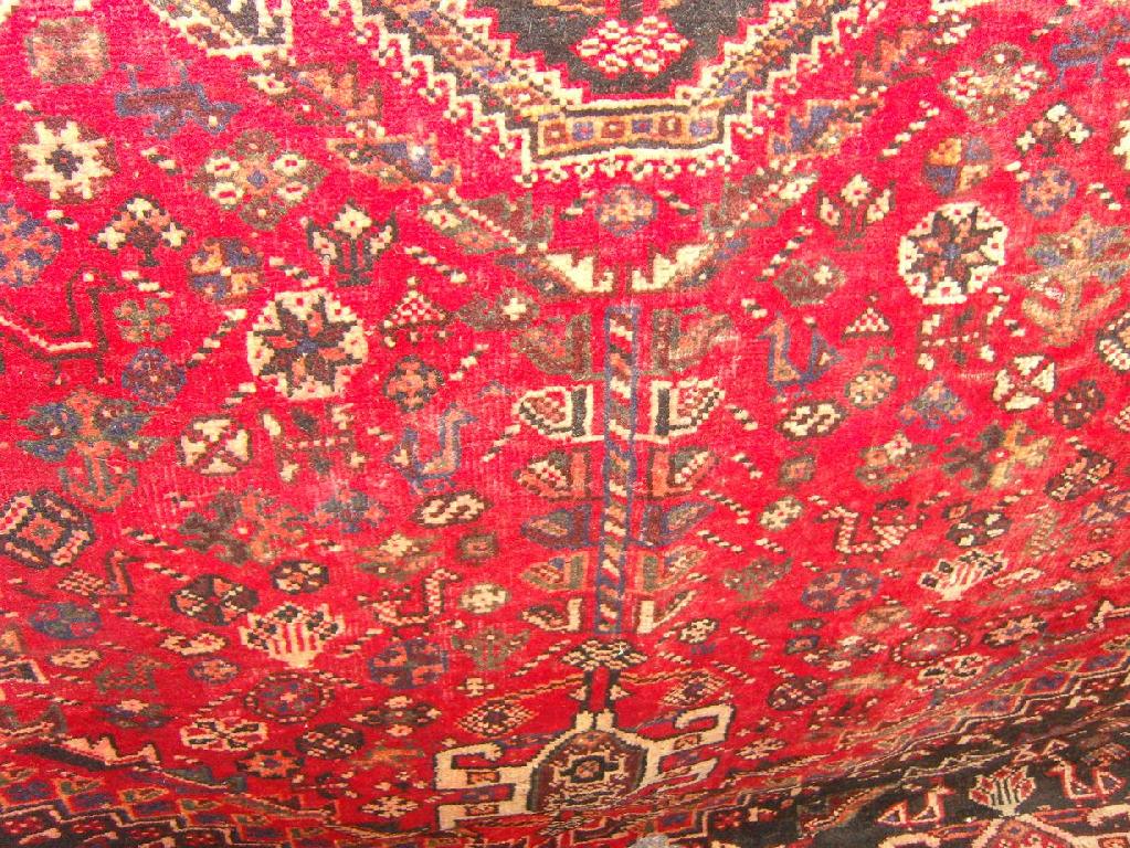 Appraisal: A red ground eastern wool carpet with polychrome stylised flower