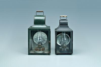 Appraisal: Two oil-burning lanterns both with wooden carrying handles clear fonts