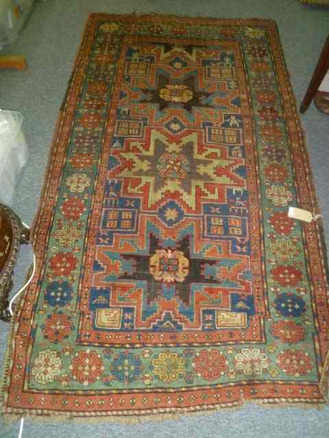 Appraisal: A CAUCASIAN BLUE GROUND RUG with central geometric designs within