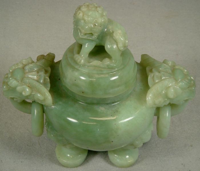 Appraisal: Carved green stone jar with foodog finial on lid ring