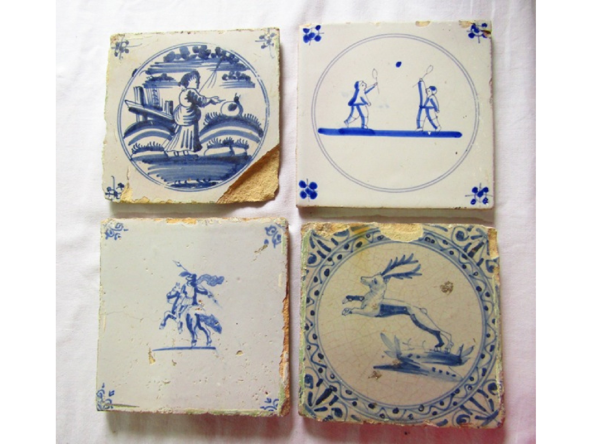 Appraisal: Four th century Delft type tin glazed earthenware tiles with