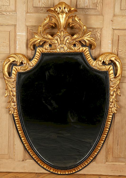 Appraisal: CARVED GILT WOOD SHIELD SHAPED MIRROR BY DAUPHINE A carved