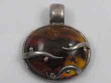 Appraisal: A silver mounted naturalistic amber pendant approx cm wide