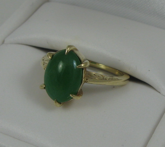 Appraisal: GREEN JADE AND FOURTEEN KARAT GOLD RING centered and prong