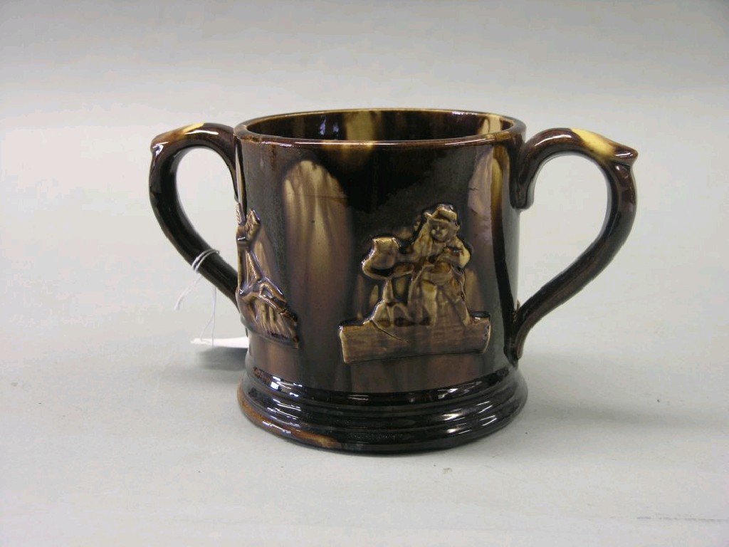 Appraisal: An early Victorian treacle-glazed earthenware frog mug two handled and