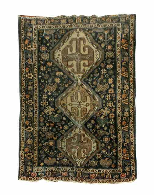 Appraisal: A SHIRAZ BLUE GROUND RUG decorated with central interlocking triple