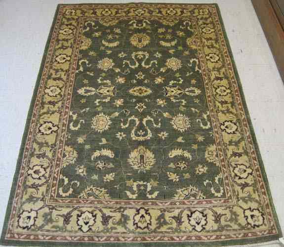 Appraisal: GREEN FIELD ORIENTAL AREA RUG Pakistani-Persian overall floral design hand