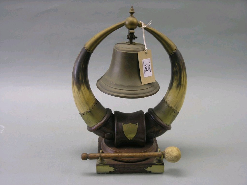 Appraisal: An Edwardian brass mounted oak dinner gong bell suspended between