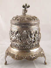 Appraisal: A Burmese white metal tests silver cylindrical box deeply embossed