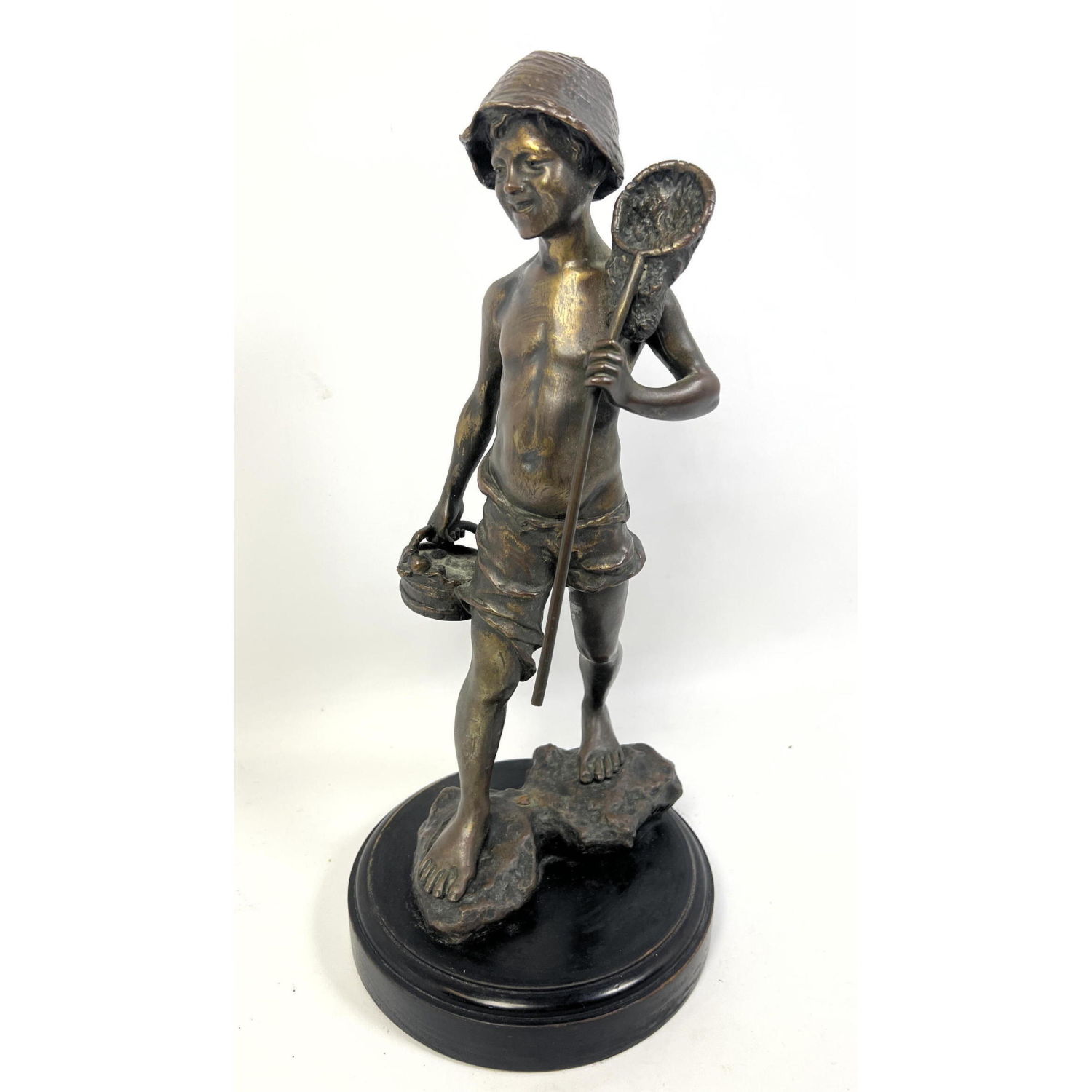 Appraisal: Bronze sculpture of boy with fishing net Mounted on wood