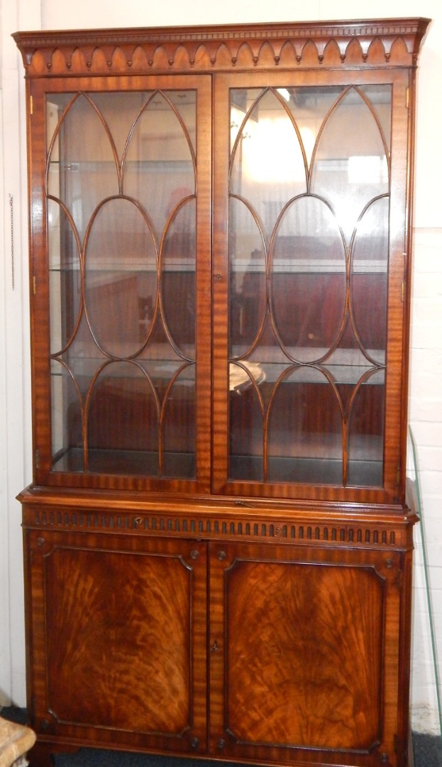 Appraisal: A Chippendale style mahogany cupboard bookcase the moulded cornice above