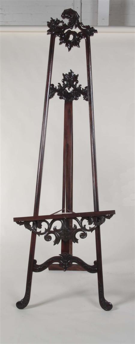 Appraisal: A large mahogany picture easel the pieced foliate carved top