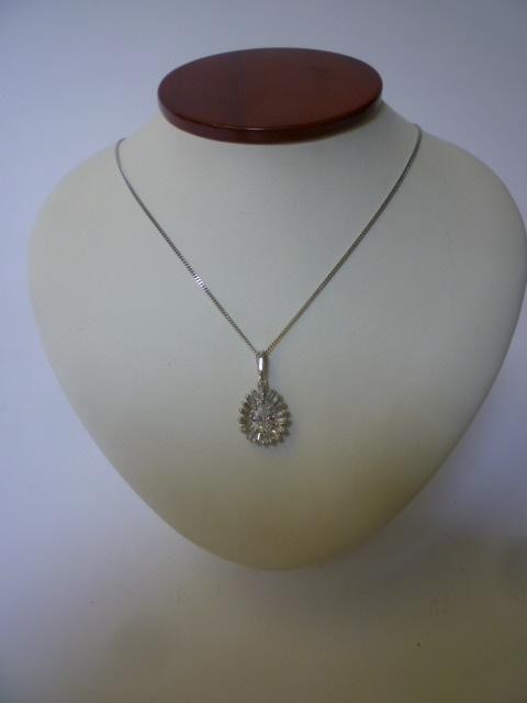 Appraisal: A DIAMOND PENDANT the pear cut central diamond set within