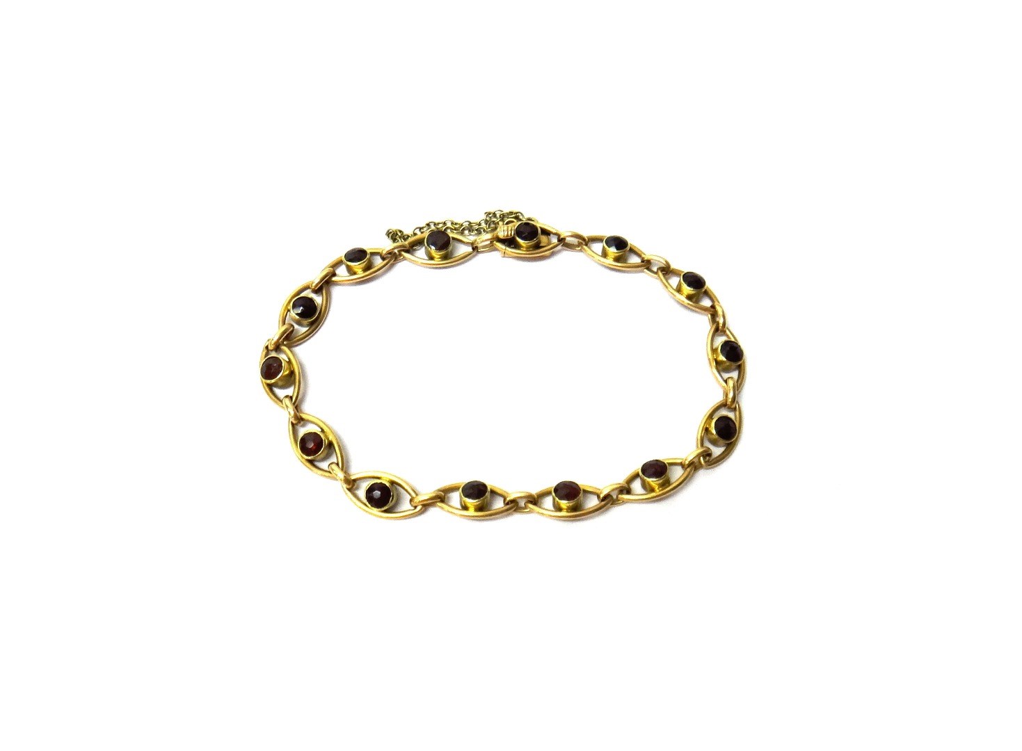 Appraisal: A gold and garnet set bracelet in an oval openwork