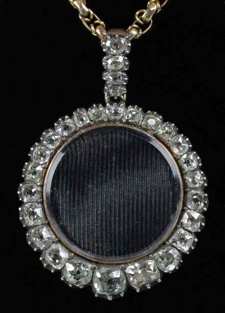 Appraisal: A pendant with border of diamonds and diamond set bail