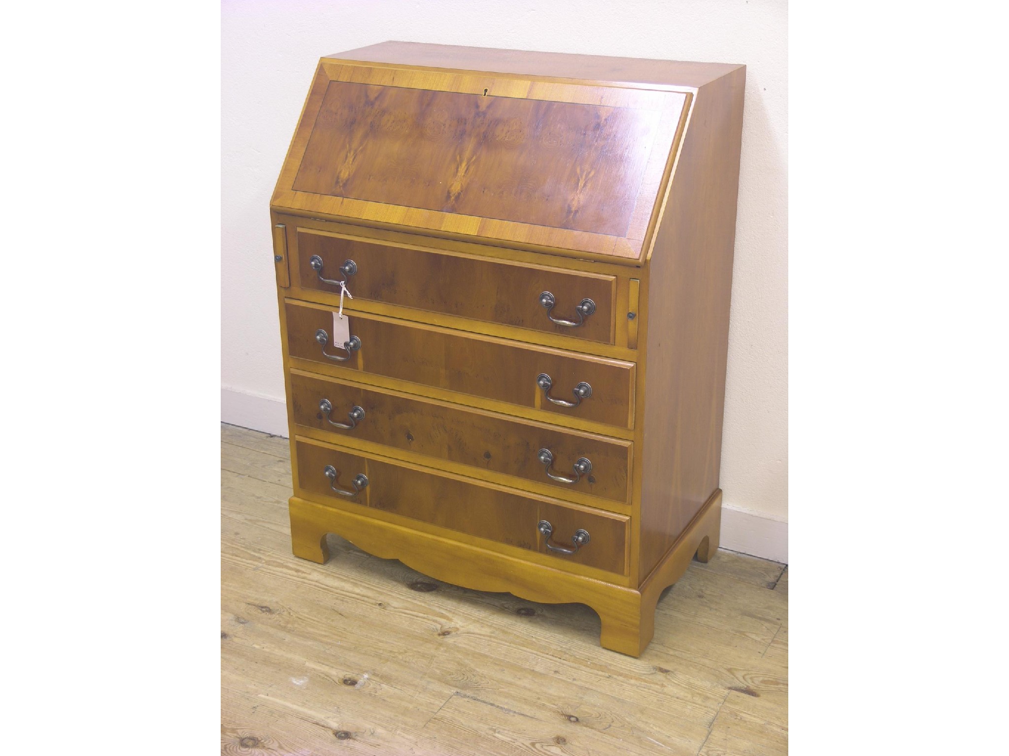 Appraisal: A reproduction yew-veneered bureau cross-banded with fall-front above four long