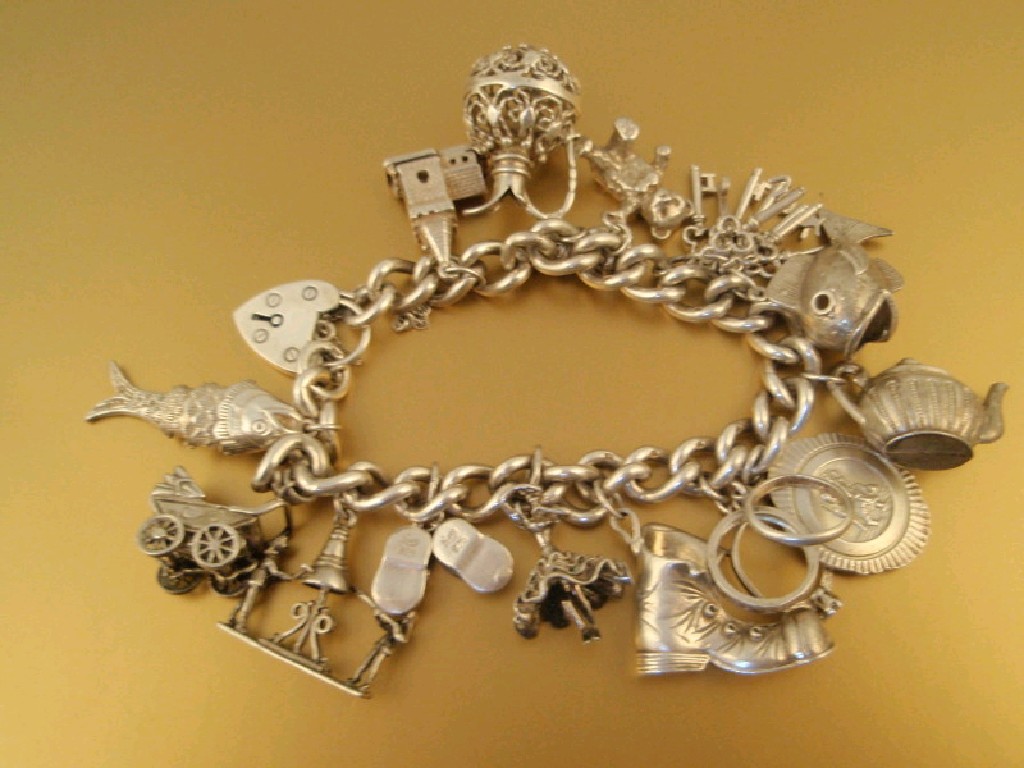 Appraisal: A heavy silver curb link chain charm bracelet fourteen charms