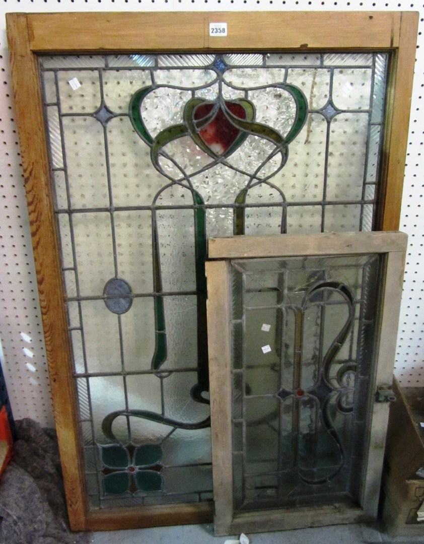 Appraisal: A pine framed stained glass panel with a similar smaller