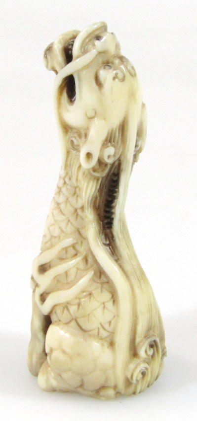 Appraisal: A thC ivory figure of a seated dragon with head