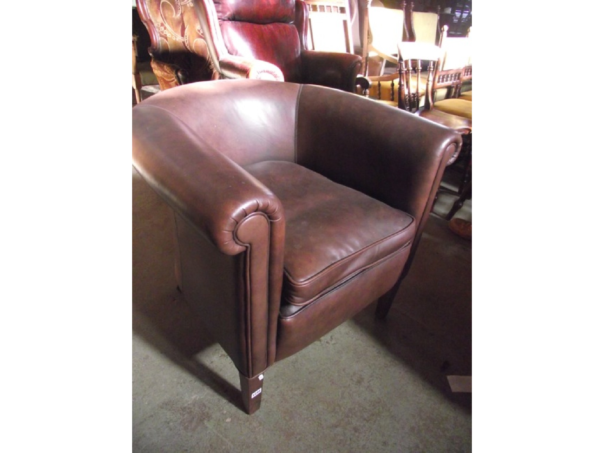 Appraisal: A contemporary tub chair with faux brown leather upholstered finish