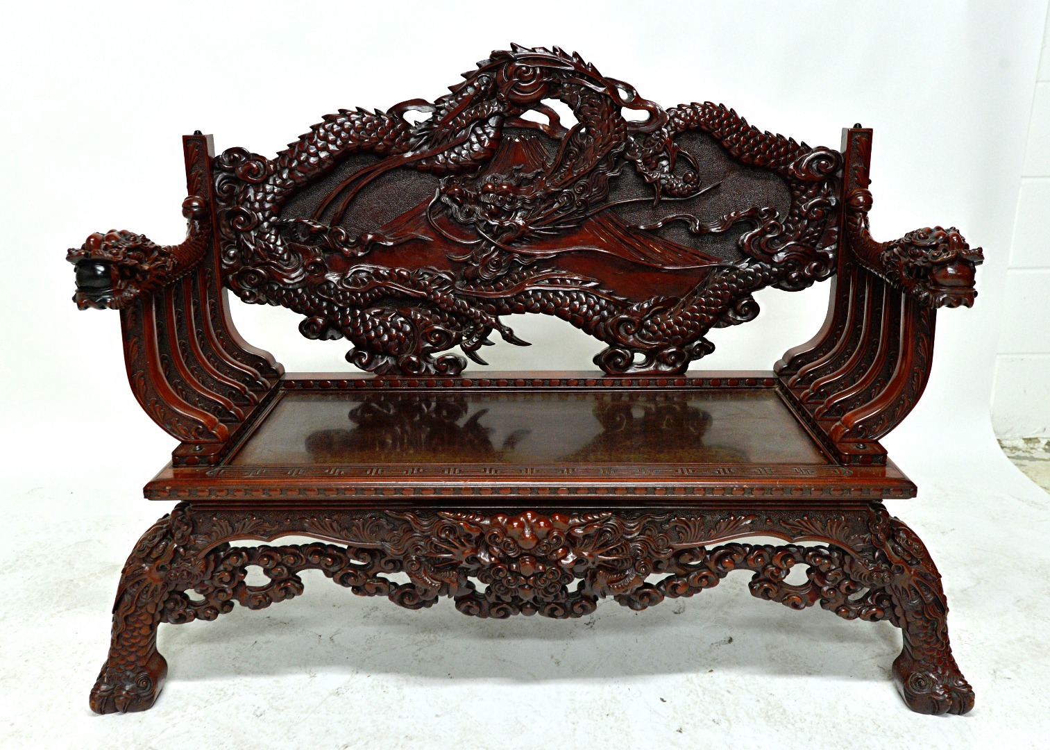 Appraisal: An early th century Chinese red lacquer bench extensively relief