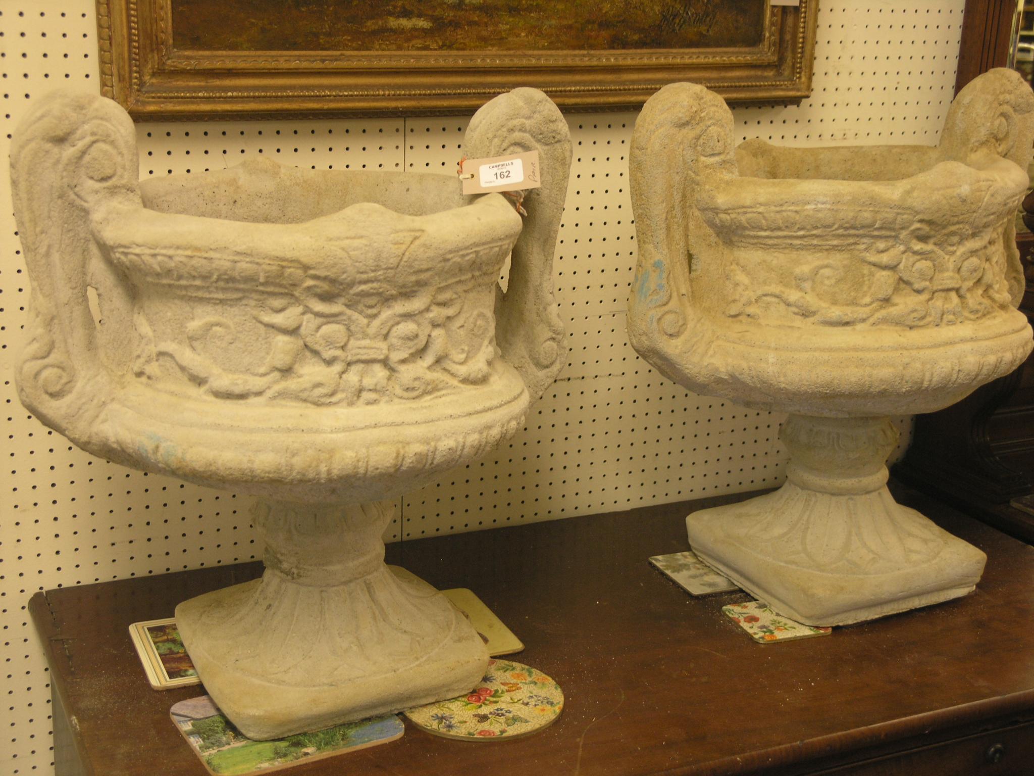 Appraisal: A pair of moulded concrete garden urns twin-handled