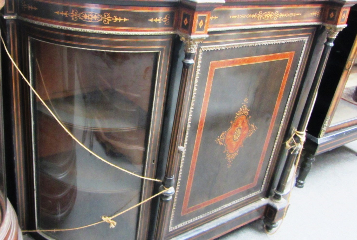 Appraisal: A Victorian marquetry inlaid ebonised and amboyna bowfront credenza with