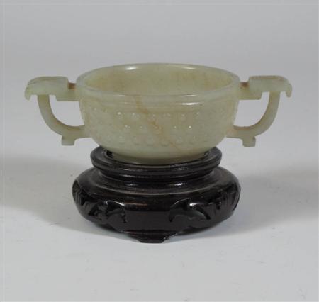 Appraisal: A Chinese pale green jade cup of two handled form