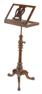 Appraisal: A carved walnut and mahogany music stand the adjustable stem