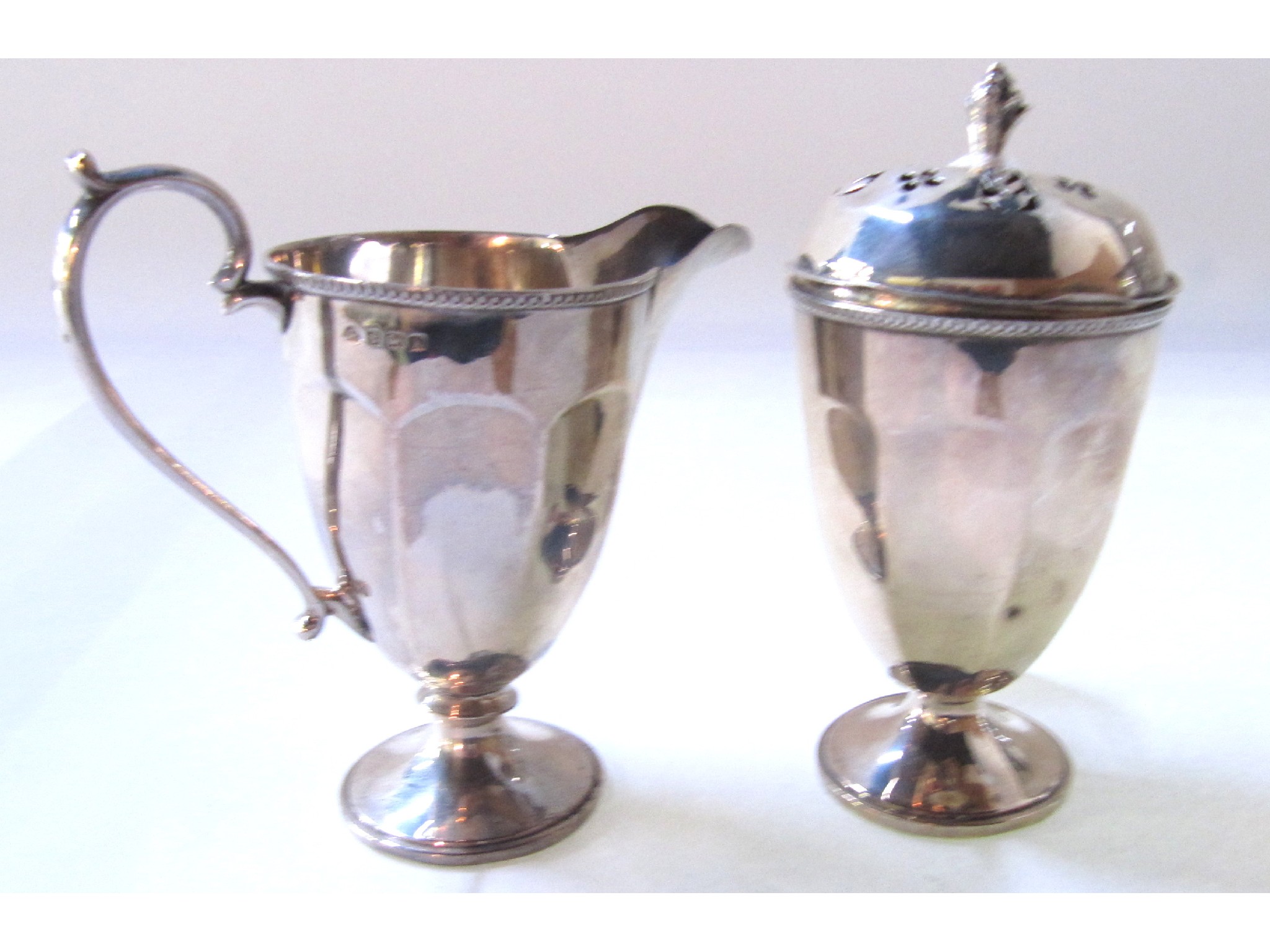 Appraisal: A silver cream jug and matching sugar castor Birmingham