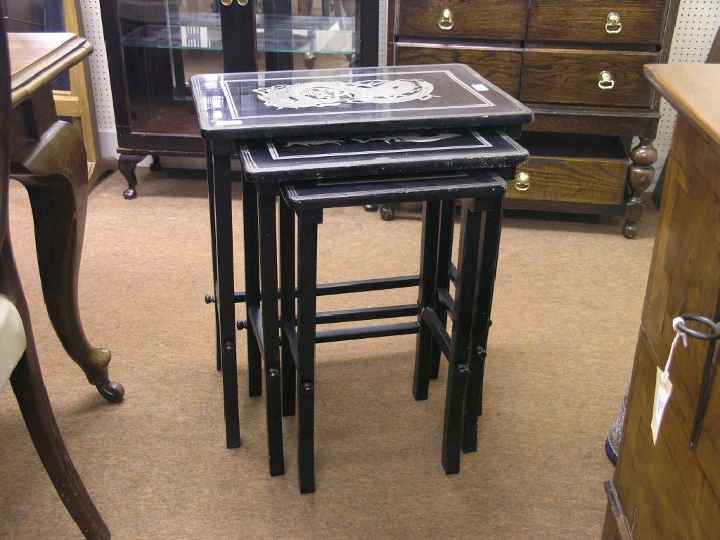 Appraisal: An oriental nest of three black lacquered tables with silvered