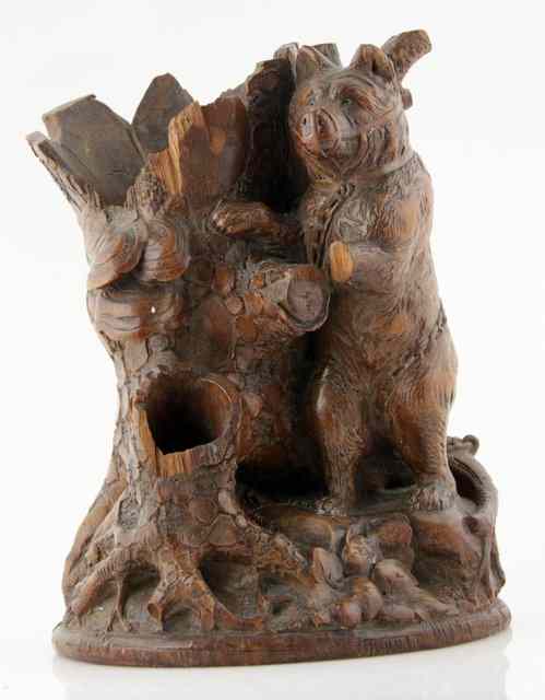 Appraisal: A Black Forest carved group bear beside a tree cm