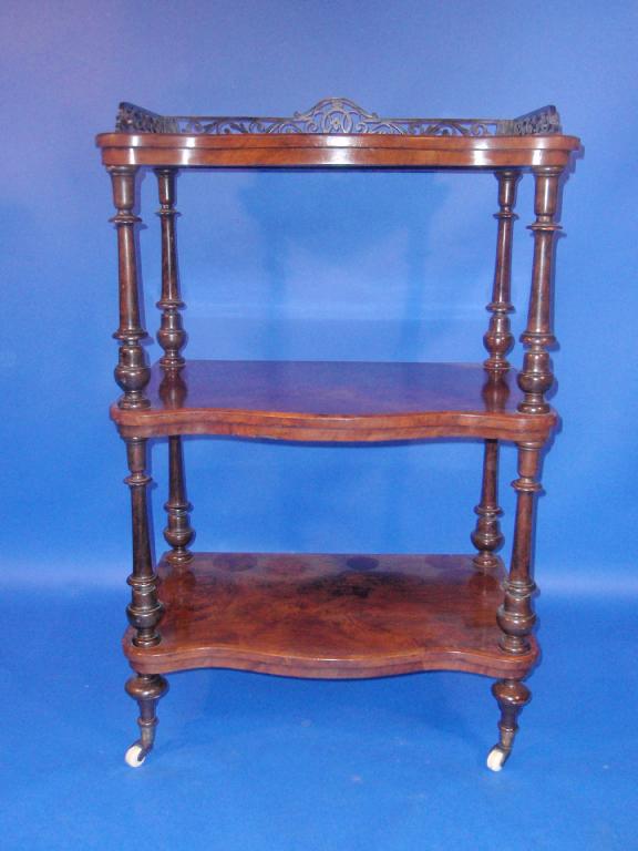 Appraisal: A Victorian figured walnut serpentine whatnot with fretwork gallery top