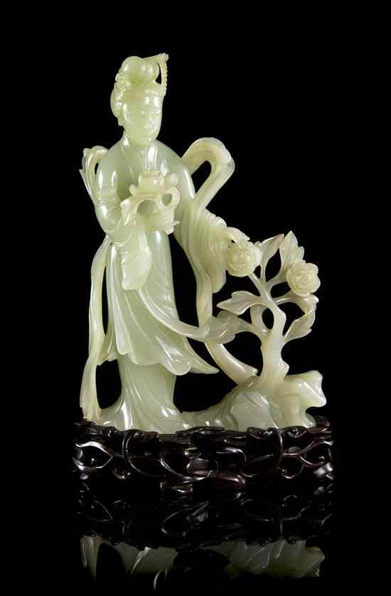 Appraisal: A Chinese Jade Carving of a Woman of pale celadon