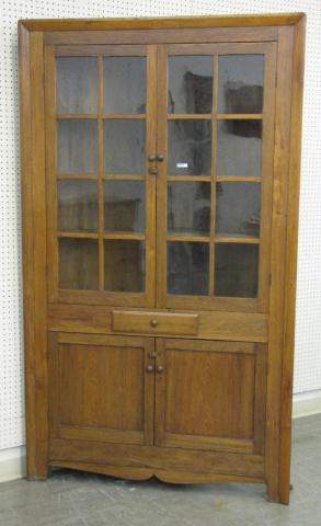 Appraisal: Primitive one-piece corner cupboard -pane glass doors walnut mixed woods