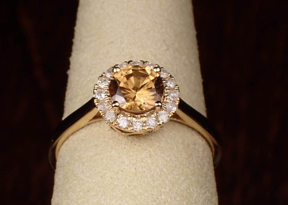 Appraisal: HONEY ORANGE ZIRCON AND DIAMOND HALO RING The k yellow