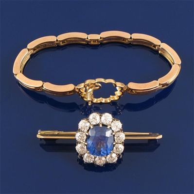 Appraisal: A sapphire and diamond cluster brooch The oval shaped sapphire