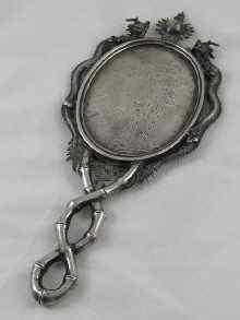 Appraisal: A Chinese silver mirror circa the oval glass flanked by