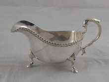 Appraisal: A Georgian style silver sauceboat with scroll handle gadrooned rim