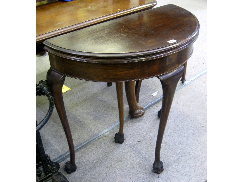 Appraisal: Mahogany demi lune fold over card table on hairy paw