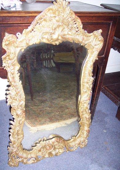 Appraisal: A Rococo style mirror of scrolling foliate outline with a